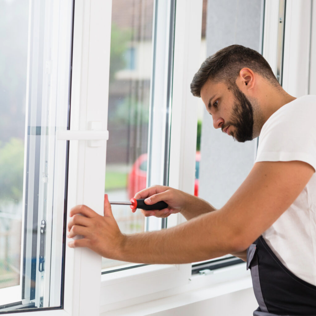 A man repairs a window using a screwdriver, focused on the task in a bright, modern interior for Window Repairs Dublin